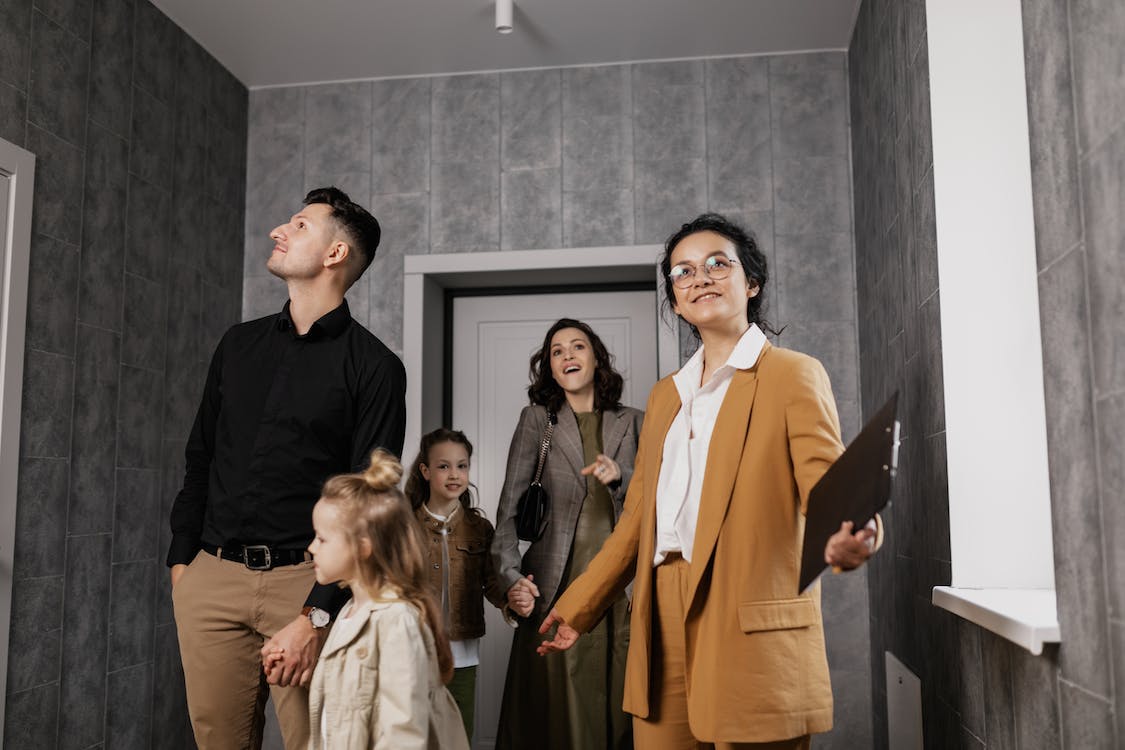 Real estate agent showing a property to a couple with kids