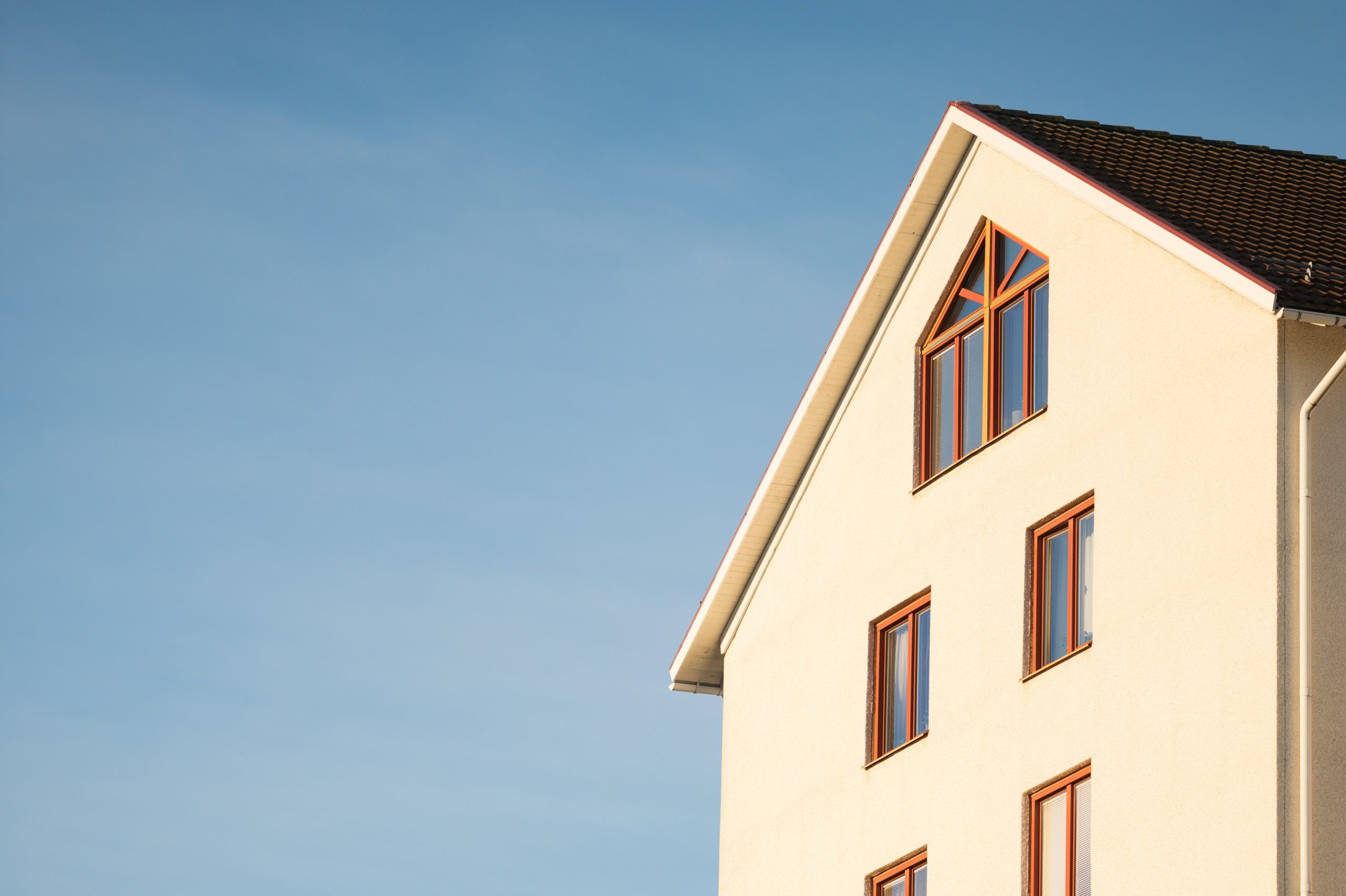 a yellow house with windows and blue sky