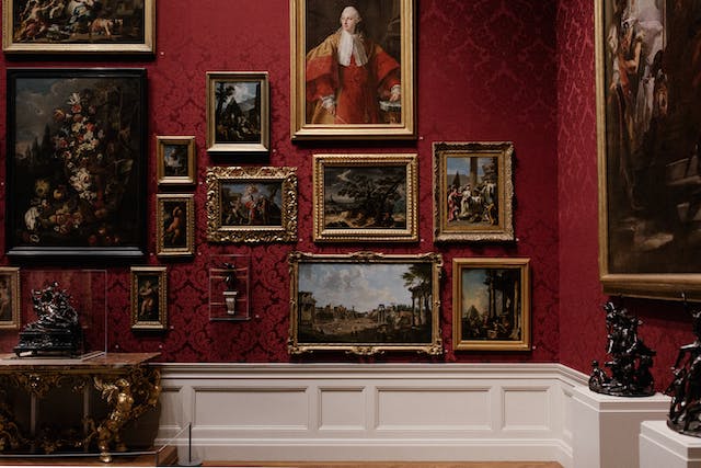 A wall with numerous paintings