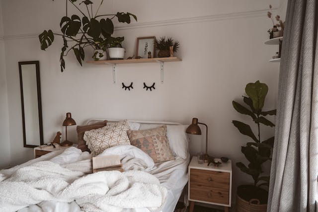Pillows on a bed near the plant in a cozy bedroom 
