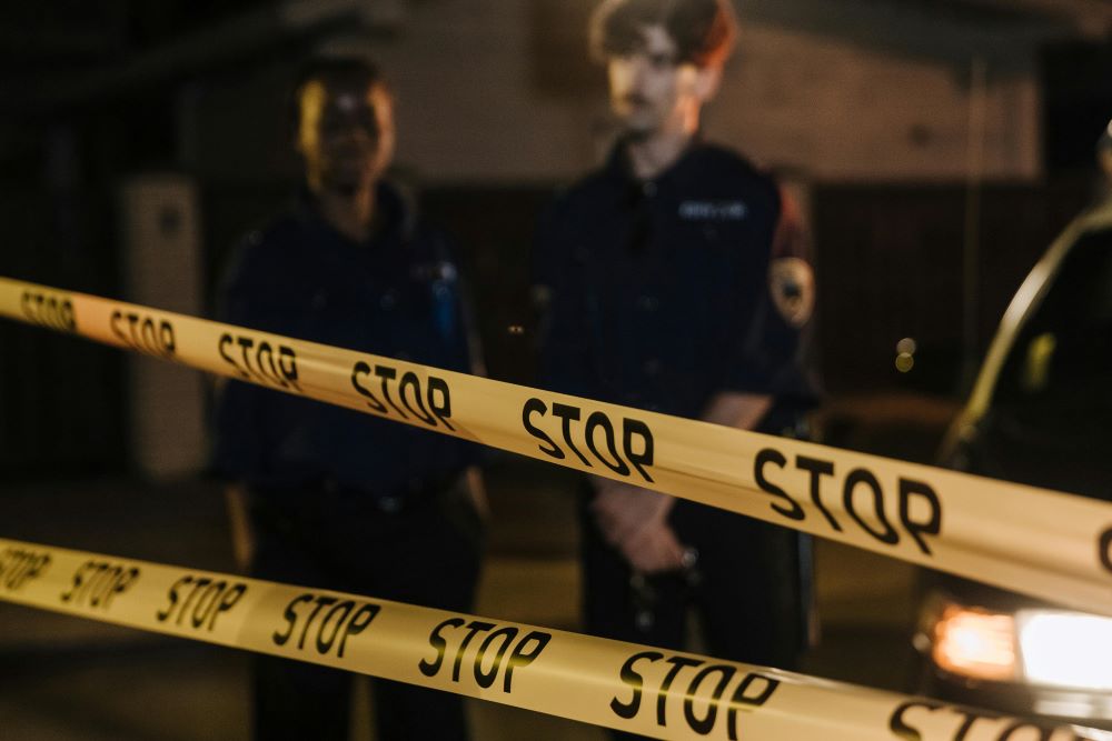 Police officers looking at yellow barricade tapes