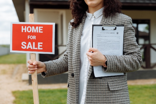 a real estate agent with a home for sale sign and a binder